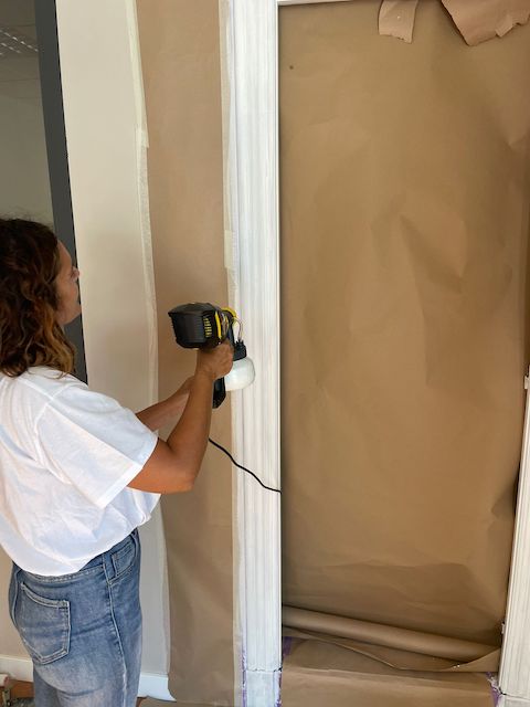 Gema pintando el marco de una puerta