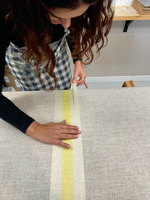 5 Ideas para renovar el cabecero de tu cama 9 Gema haciendo el diseño con cinta adhesiva en el cabecero que vamos a pintar