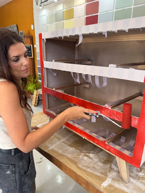 Gema pintando en rojo la cómoda