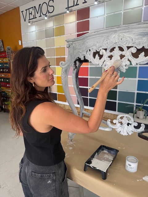 Gema aplicando la pintura en el mueble con brocha