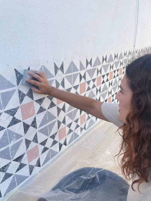 Gema lijando el zócalo de la cocina de exterior