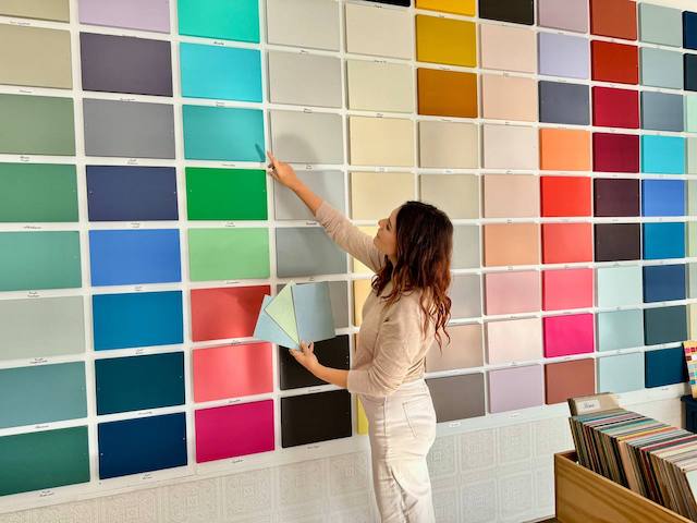 Cómo elegir el color perfecto para el salón 17 Gema haciendo comparaciones de color con muestras en la pared