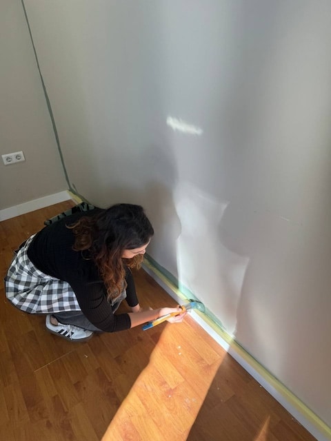 Gema recortando la pared con brocha y pintura