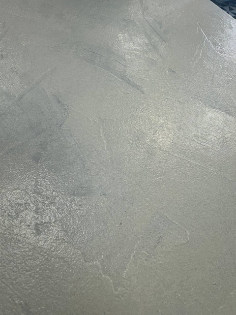 Masilla de texturas extendida con espátula sobre la tapa del mueble que vamos a pintar al estilo Shabby Chic