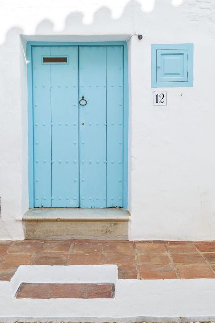 Puerta pintada azul y fachada blanca