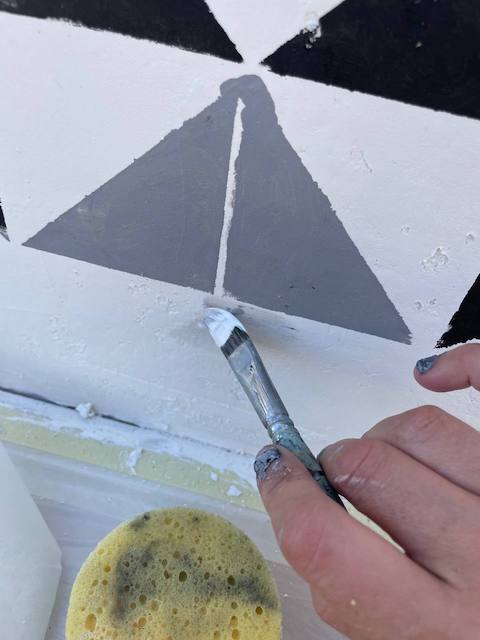 Repasamos con pincel el zócalo pintado de la cocina de exterior