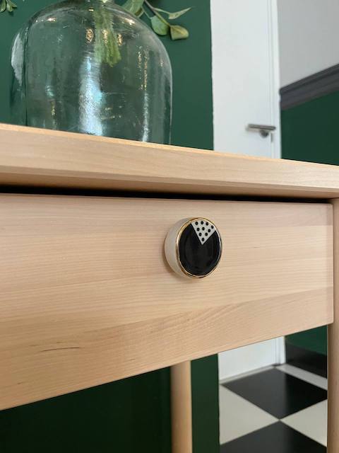 Ideas para personalizar tus muebles con tiradores 27 Tirador negro y dorado en mesilla de madera