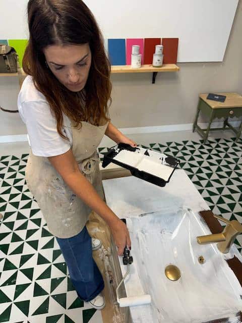 Gema pintando el lavabo de cristal con rodillo