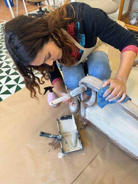 Gema pintando la estructura del sillón con agua color Lino.