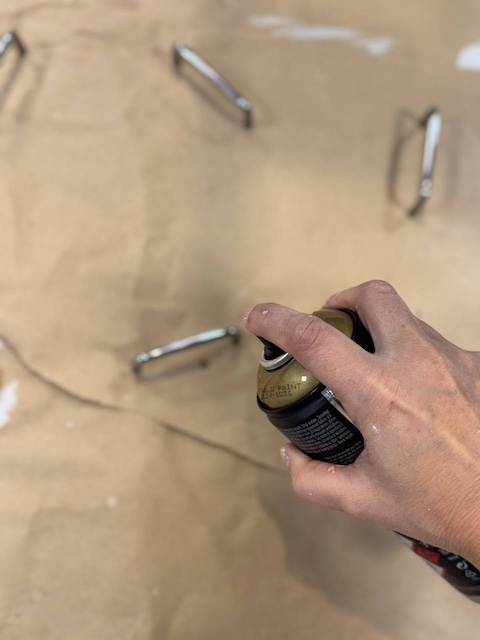 Aplicamos pintura en spray a los tiradores de la cajonera de metal